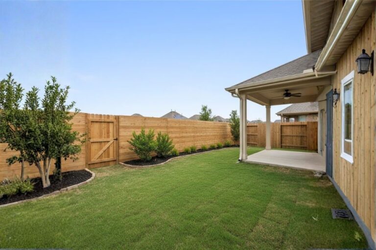Residential backyard with wooden fence and patio in Firethorne, Katy, Texas.