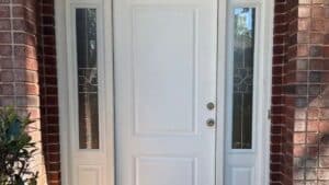 A white residential front door with side windows, maintained by a local handyman in Katy.